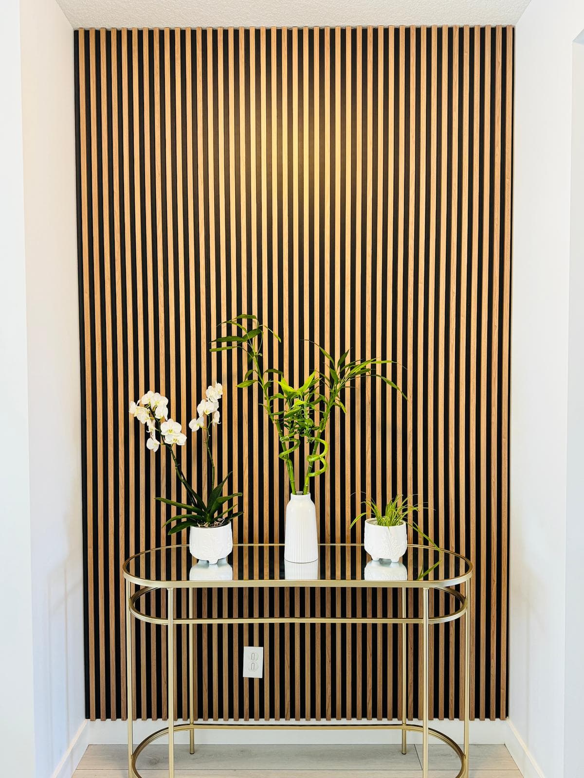 Black WPC slat accent wall with round mirror